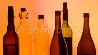 玻璃、瓶子和酒精在发光背景上的图像。